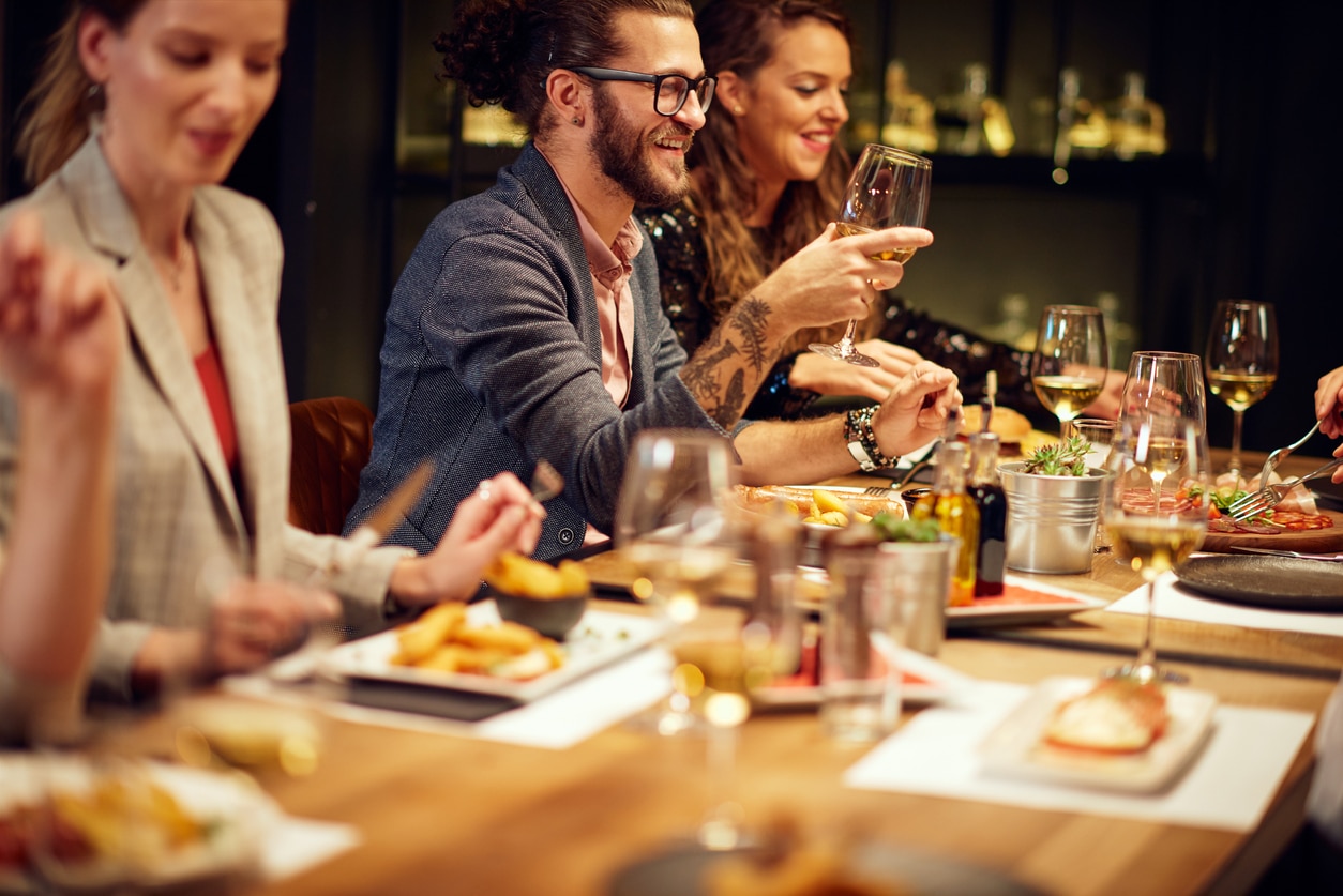 Corporate holiday dining - A group of employees enjoying a corporate dinner at a restaurant.